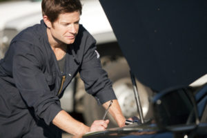 Young mechanic fixing a car